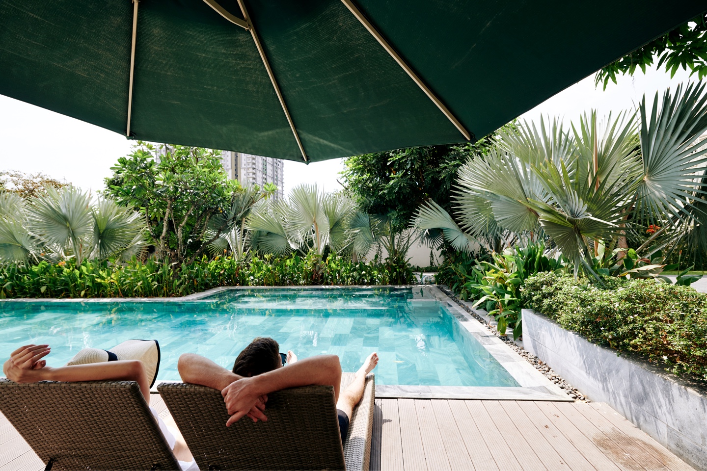 couple-pending-time-by-secluded-swimming-pool-AAYW37A